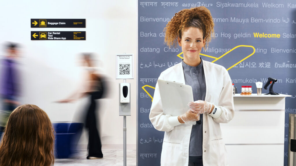 A medical assistant greets passengers arriving at an airport terminal
