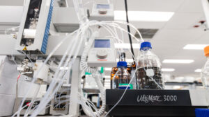 Various reagents in bottles being fed via tubes via an automated workflow to provide mutagenesis effects to strains in a non-GMO experiement